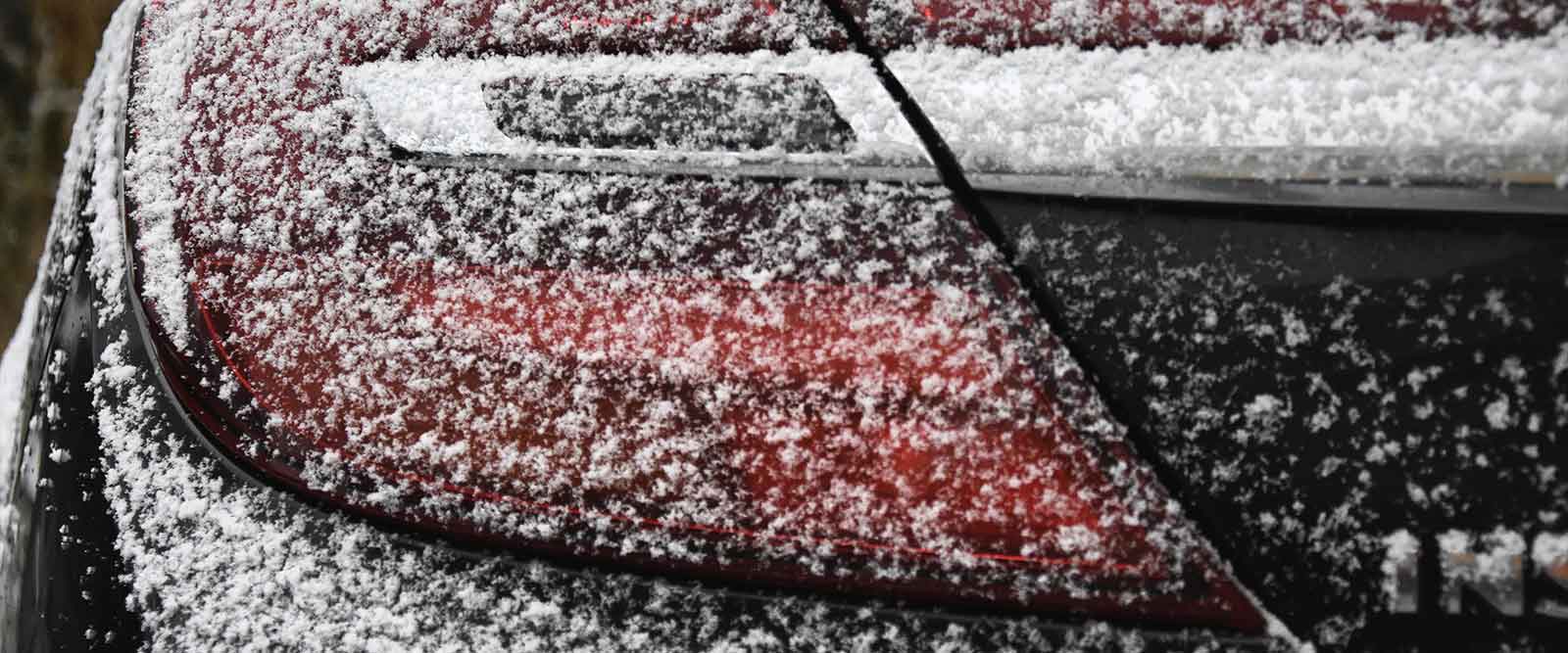 Fahrzeugaufbereitung im Winter - Rückseite eines verschneiten Autos