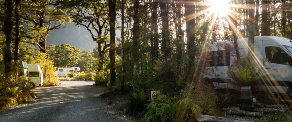 Camping Knigge - Wald mit Campingwagen