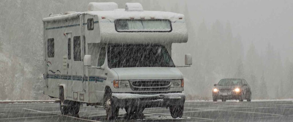 Wohnmobil nach dem Winter reinigen - Wohnwagen im Regen auf Parkplatz