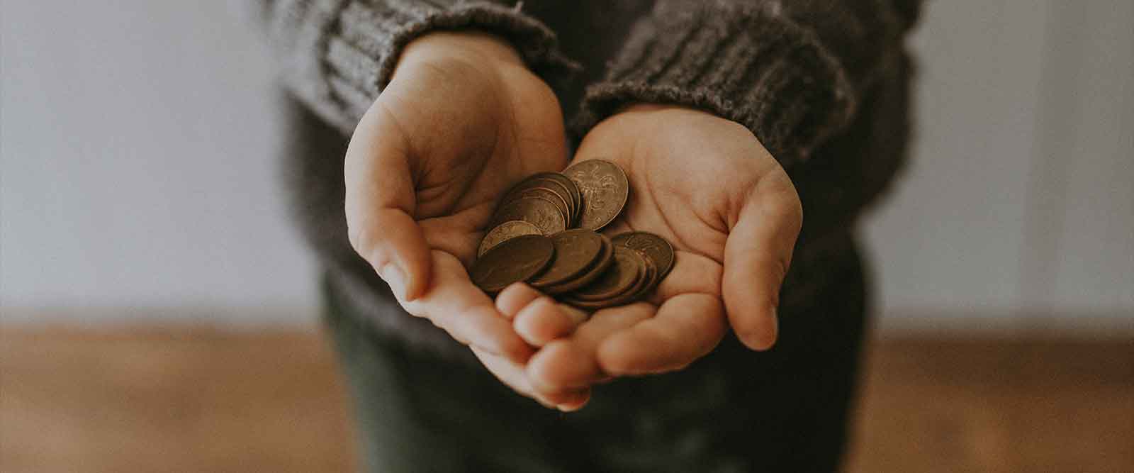 Fahrzeugaufbereitung Fixkosten berechnen - In zwei Händen liegen Geldstücke