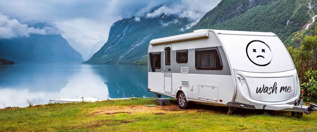 Camper Pflege unterwegs- Camper steht dreckig vor schöner Landschaft